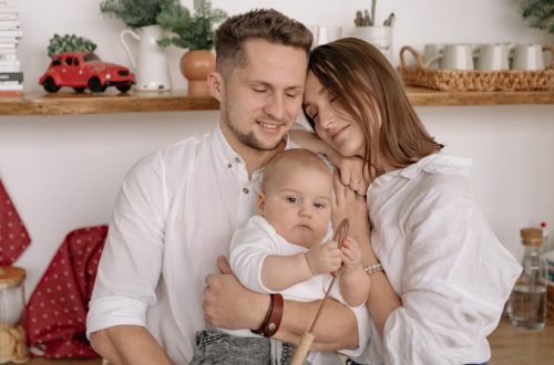 A joyful family of three embracing in a cozy kitchen. Warm and loving atmosphere.